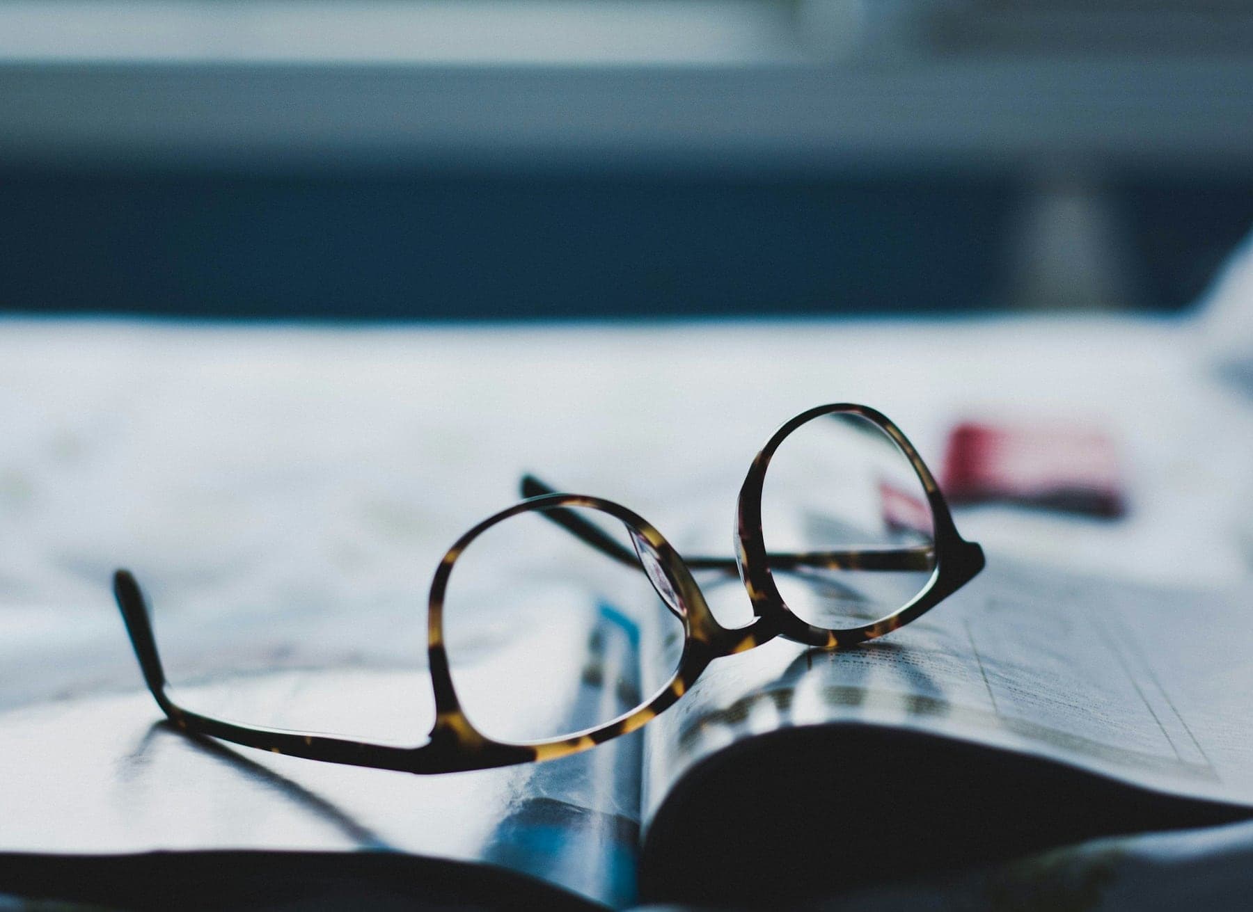 Tortoiseshell frames resting on a magazine