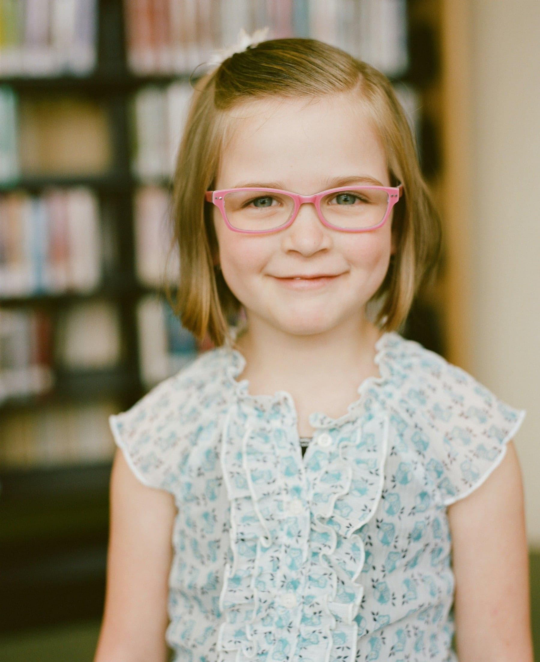 Smiling girl wearing pink-framed glasses